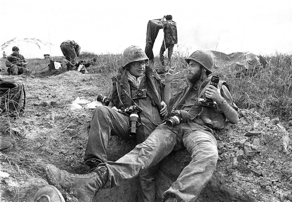 UPI photographer David Hume Kennerly, (R), and Time Magazine photographer Dirck Halstead along Highway 13 after surviving a major ambush by North Vietnamese regular forces near Chon Thanh, Vietnam