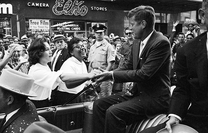 John F. Kennedy greets supporters from his motorcade during a campaign sweep through Texas.